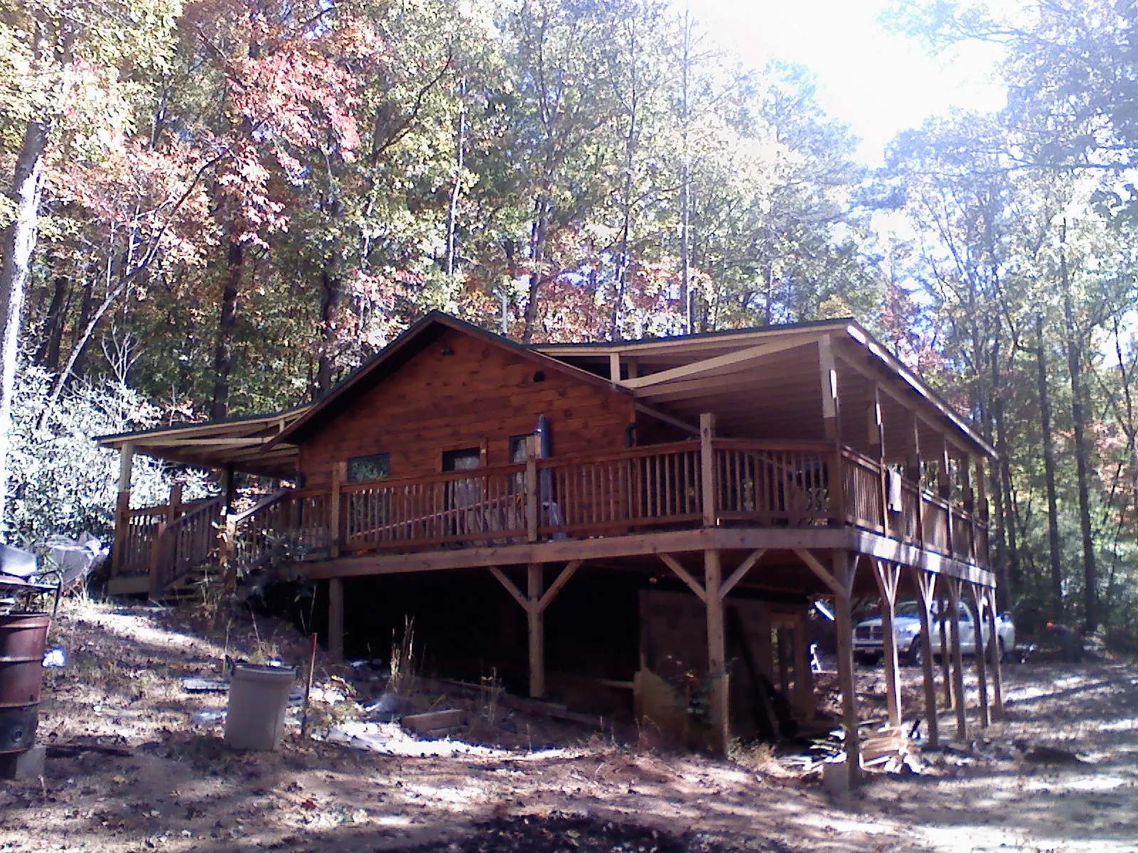 Log cabin with a wraparound porch and metal roof in the fall in Brunswick