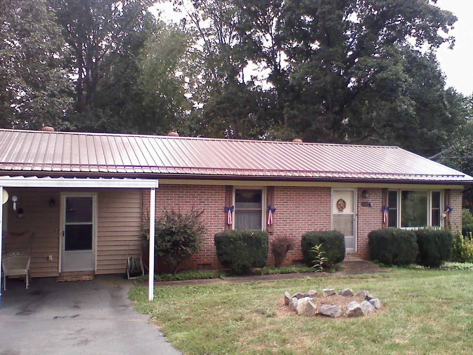 Bronze metal roof and carport on a brick ranch home — Roof Repair work by our crew in Brunswick